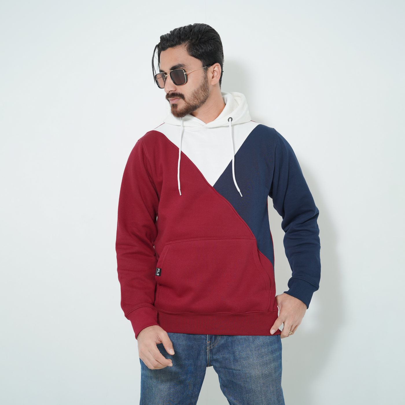 Male model in a Fils Premium Pullover Hoodie – Colorway. Stylish tri-color design in cozy crimson, navy, and white, casual fit