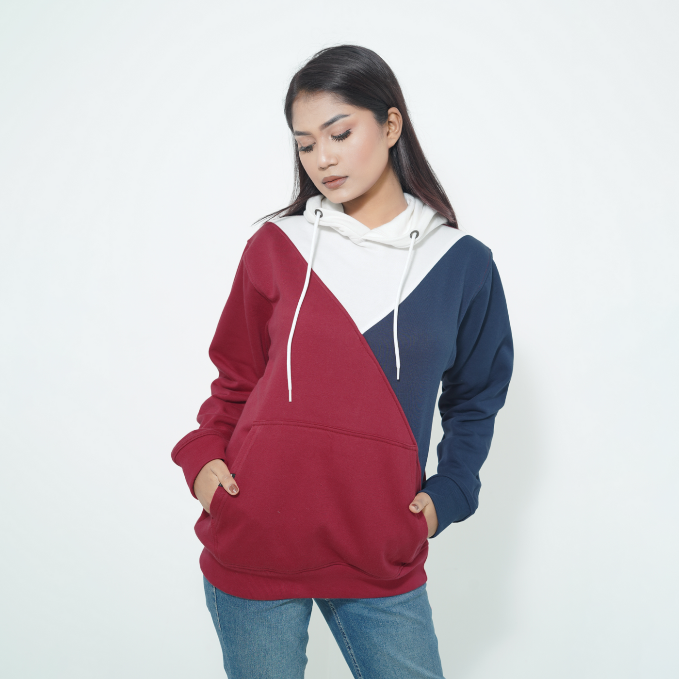 Female model in a Fils Premium Pullover Hoodie – Colorway. Stylish tri-color design in cozy crimson, navy, and white, casual fit