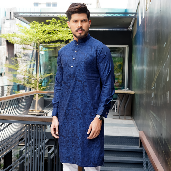 A man wearing a blue jacquard cotton panjabi with a geometric pattern, standing outdoors.