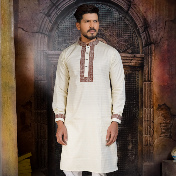 A man wearing an off white premium embroidered cotton panjabi with full sleeves, featuring intricate patterns and designs.