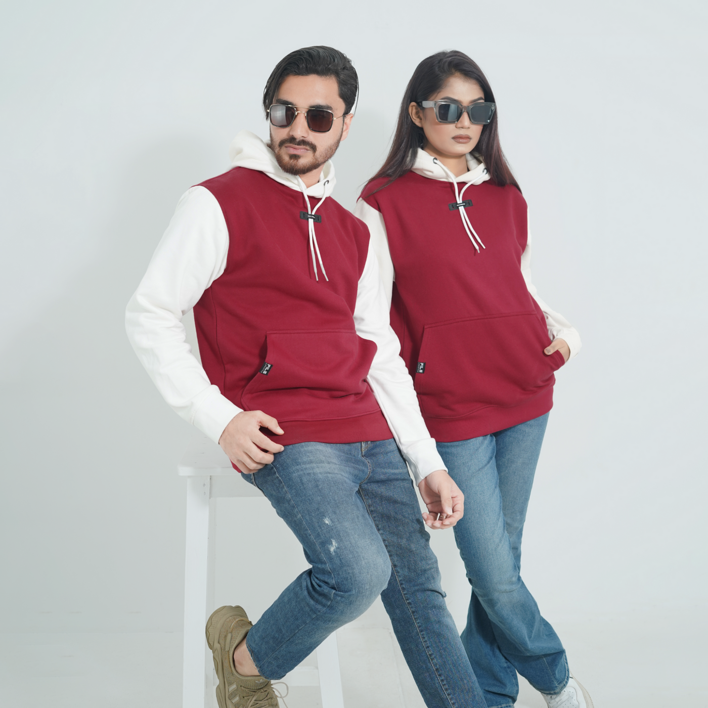 Male and female models wearing Cozy Crimson color Fils Lifestyle Premium Pullover Hoodie.