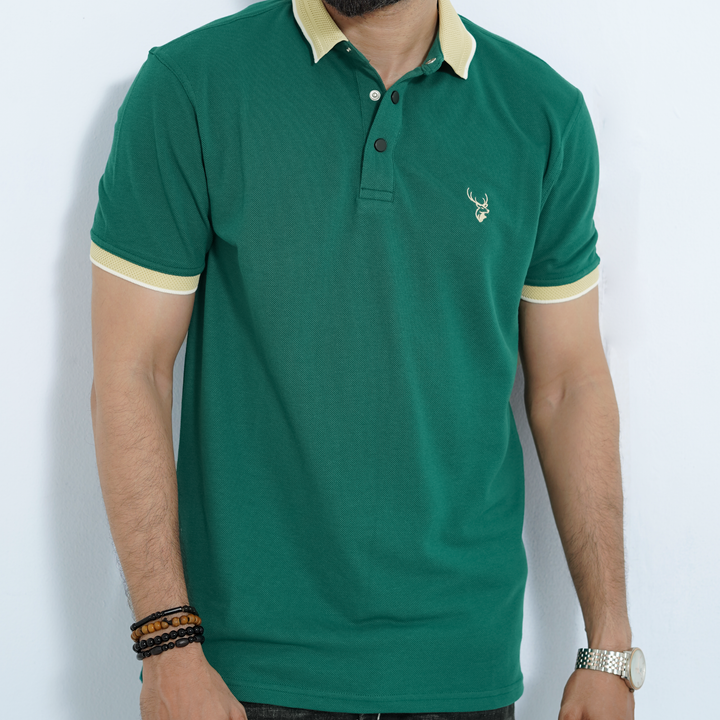 Green polo shirt with a small fils logo worn by a person on a white background