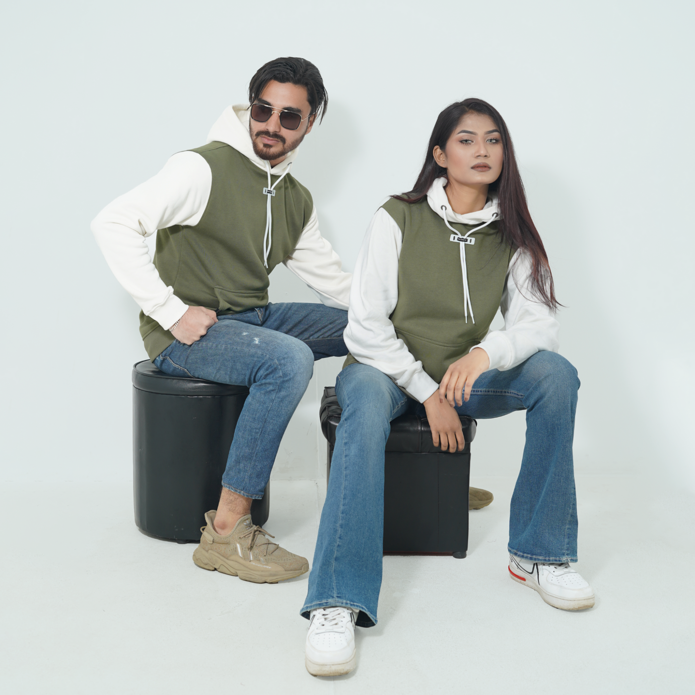 Male and female models wearing the Fils Lifestyle Premium Pullover Hoodie in Olive Mist