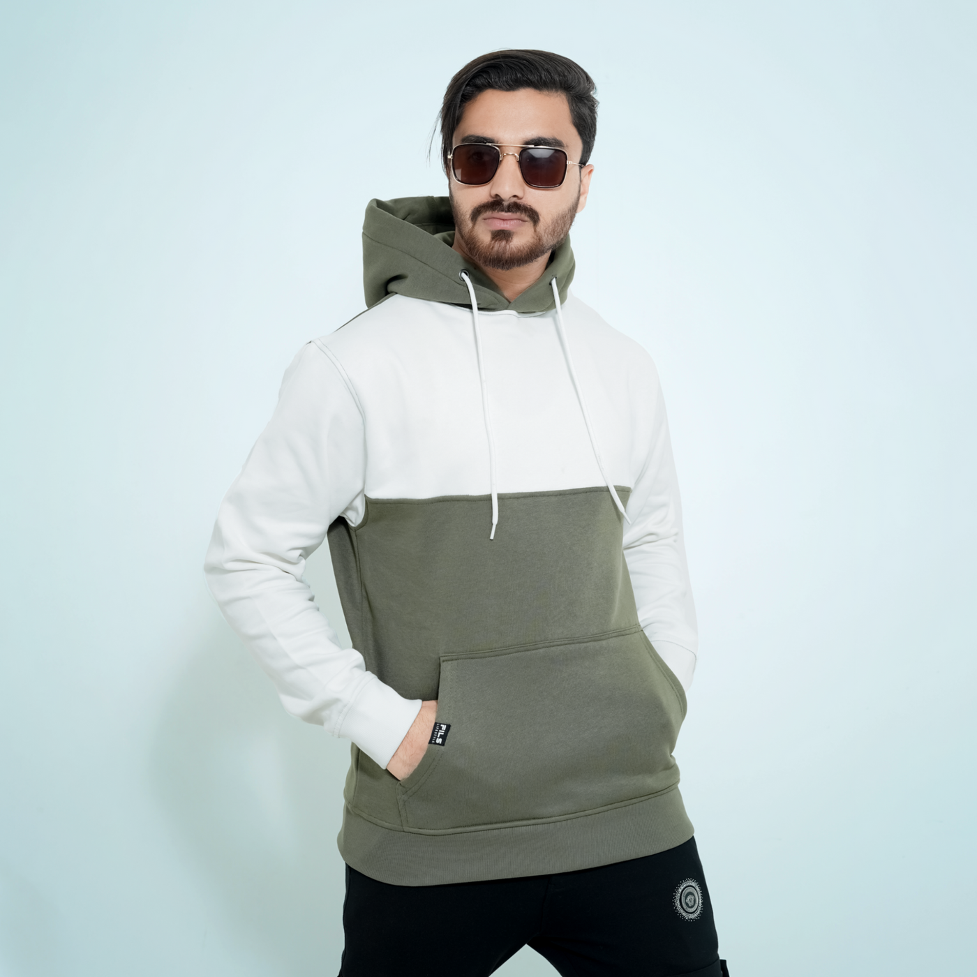 Male model wearing the Fils Premium Pullover Hoodie in Frosty Olive.