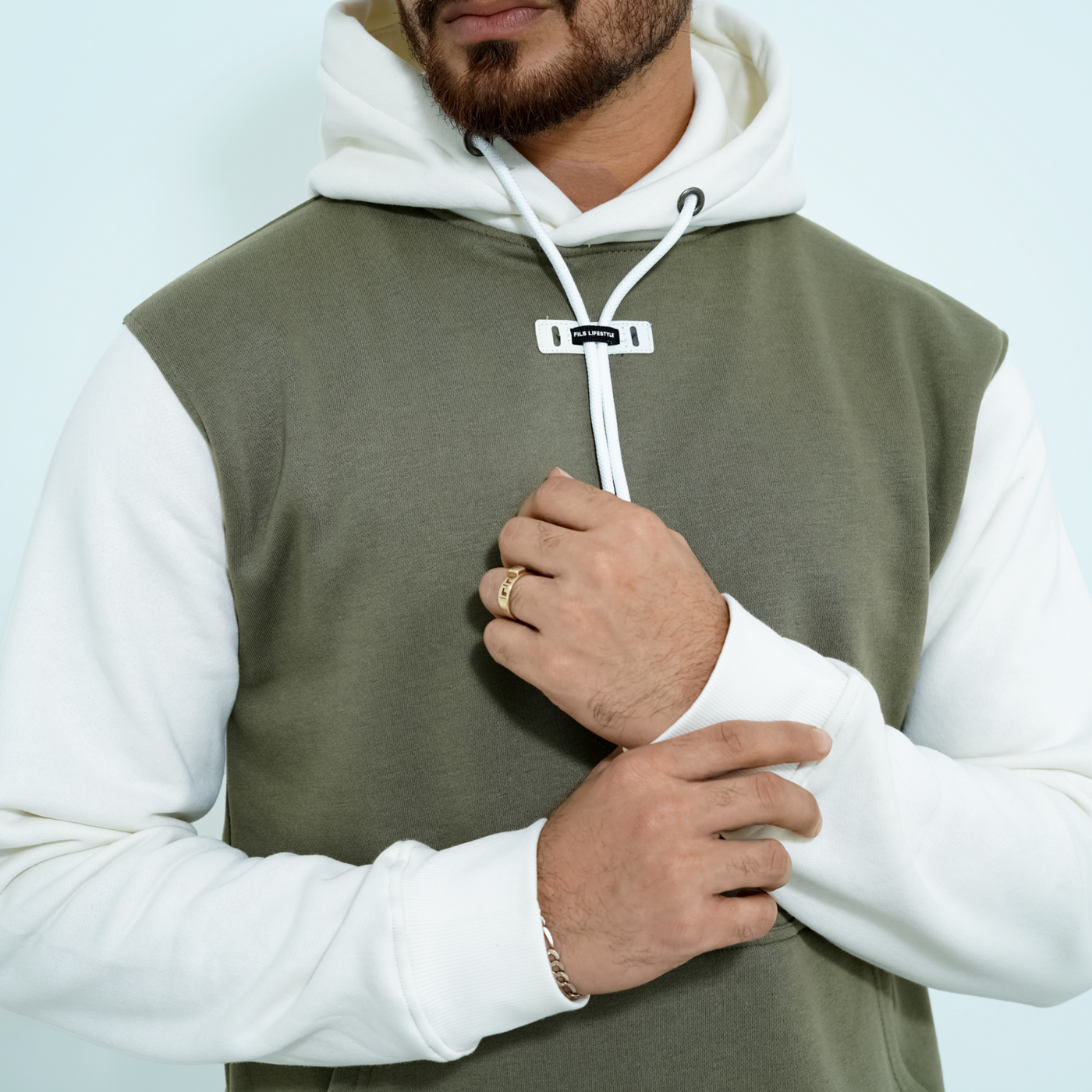 Male model wearing the Fils Lifestyle Premium Pullover Hoodie in Olive Mist showing sleeve
