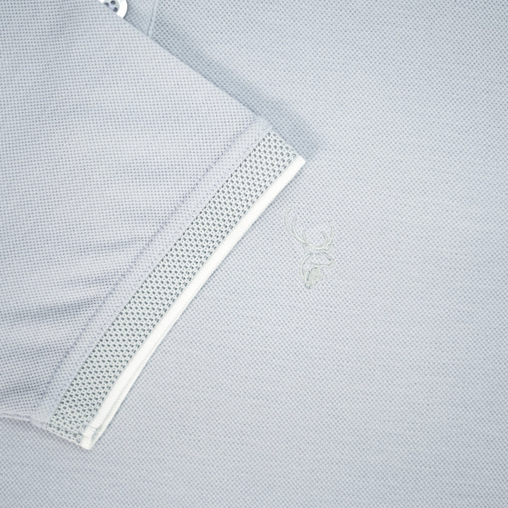 Close-up of a light gray shirt with a mesh panel on a light gray background