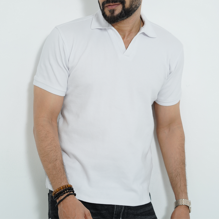 Man wearing a plain white polo shirt against a light background