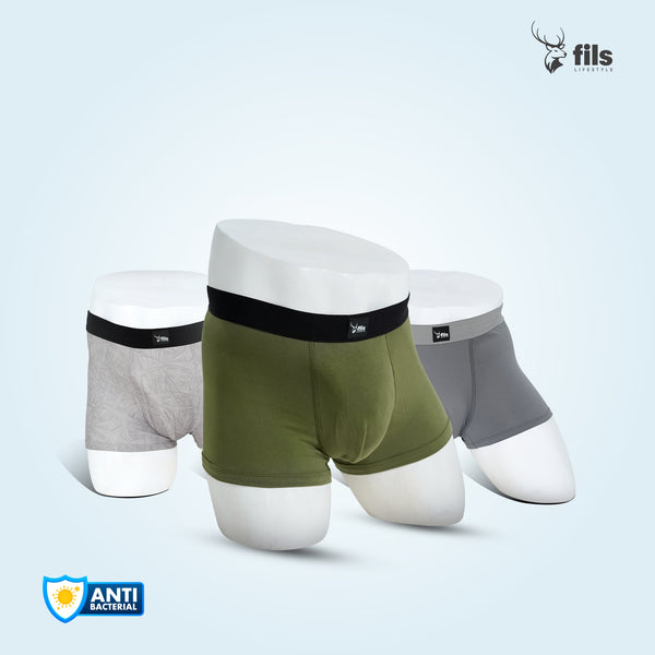Three pairs of men's underwear in green, gray, and white on a dark background with 'fils' branding.