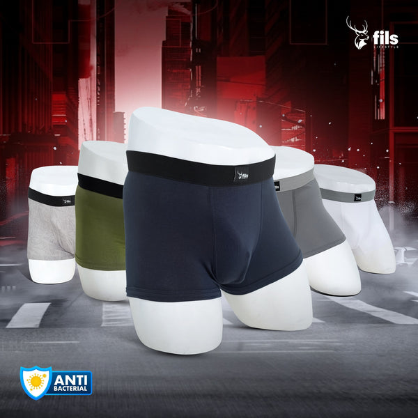 Men's underwear displayed on mannequin legs with a dark urban background