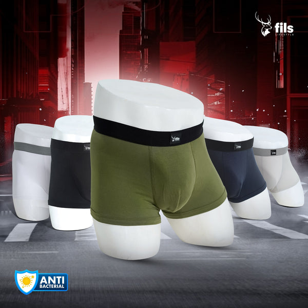 Set of men's underwear displayed on mannequin forms with a dark industrial background.