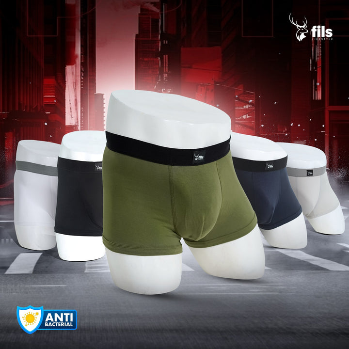 Set of men's underwear displayed on mannequin forms with a dark industrial background.