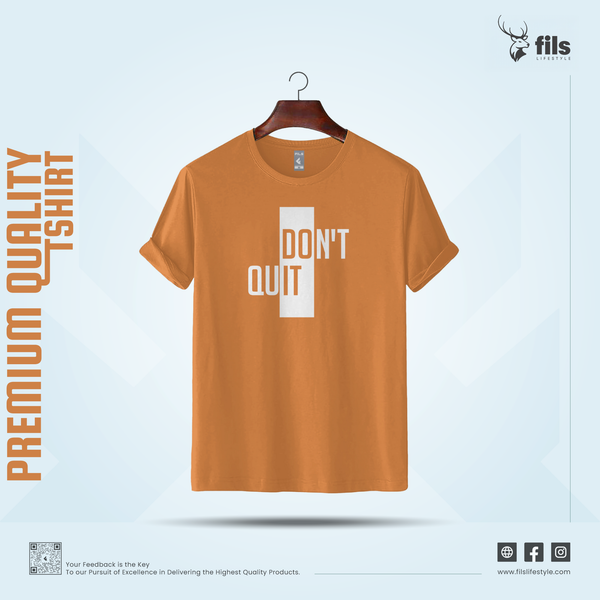 Orange t-shirt with 'DON'T QUIT' text on a hanger against a light blue background, featuring the brand 'fils'.