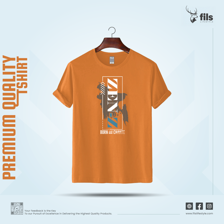 Orange t-shirt with graphic design on a hanger against a light blue background, featuring the brand 'fils'.