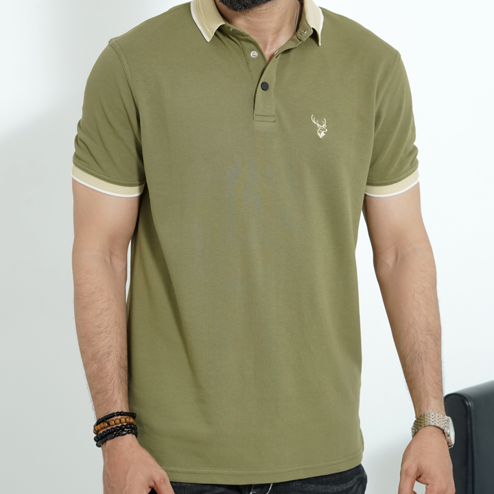 Person wearing a green polo shirt with fils logo on a white background