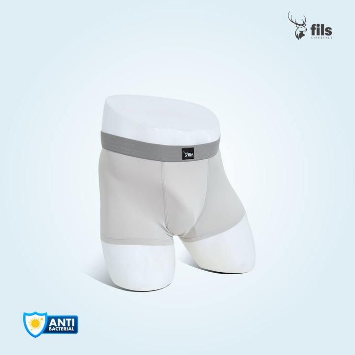 Silver boxer briefs with gray waistband on a city street background, featuring the brand 'fils'.